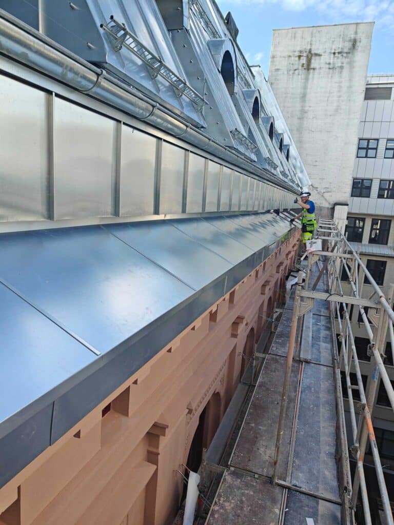 Montering og kontrollarbeid på zinktekking og beslagsarbeider fra stillas i Øvre Vollgate, Oslo.