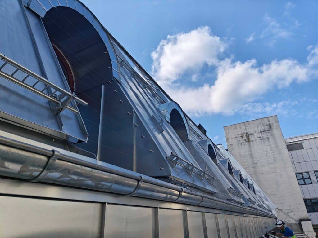 Zinktekket skråtak med arketak og monterte snøfangere langs takflaten i Øvre Vollgate, Oslo.